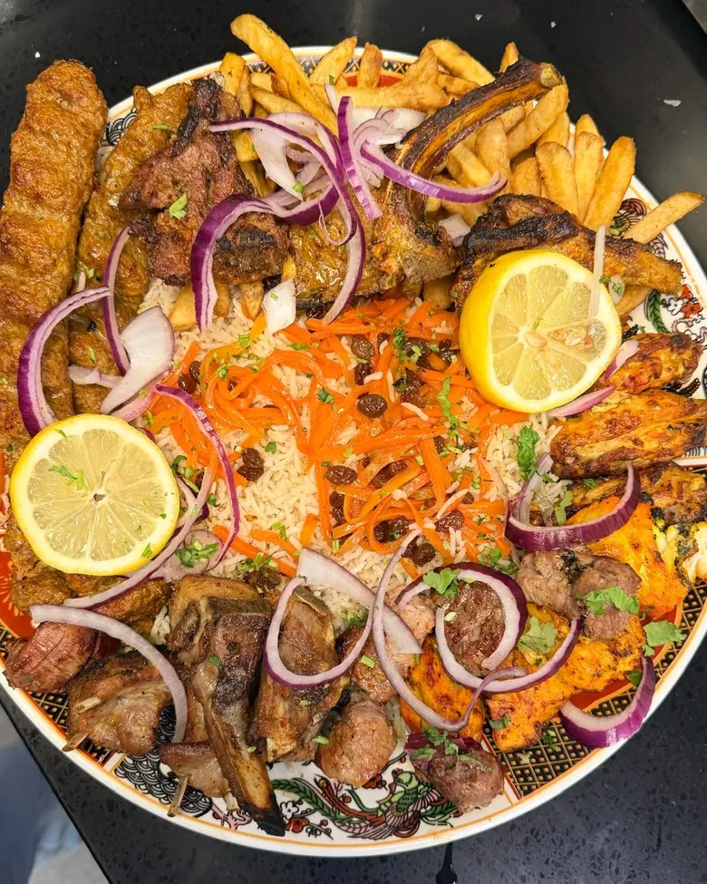 Zaiqa-E-Mehfil mixed grill platter: seekh kebabs, lamb chops, ribs, chicken tikka and wings over Kabuli rice